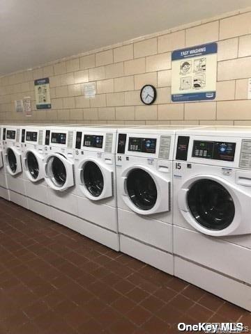 102-10 66th Road, Unit 14C Queens, NY 11375 - Photo 10 of 10 Communal laundry room with washing machine and dryer and dark tile patterned flooring