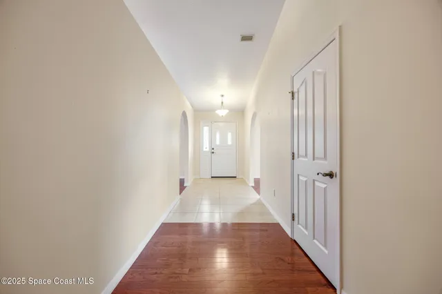 a view of a hallway with wooden floor