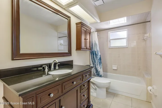 a bathroom with a double vanity sink toilet mirror and bathtub