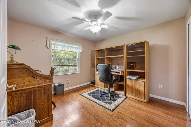 a view of workspace with wooden floor furniture and windows