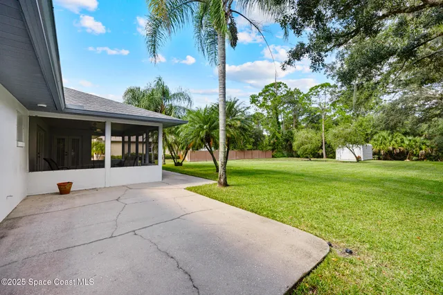 a view of a house with backyard and a tree