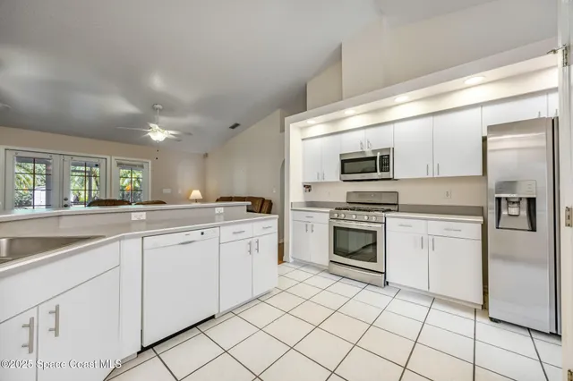 a kitchen with white cabinets appliances and sink