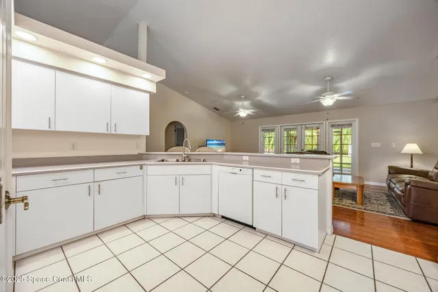 a kitchen with white cabinets a sink and appliances