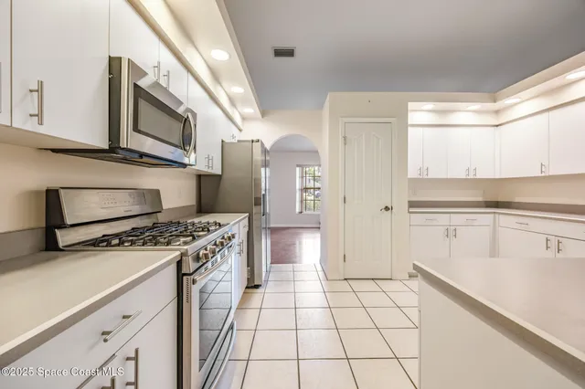 a kitchen with stainless steel appliances granite countertop a stove a sink and a refrigerator