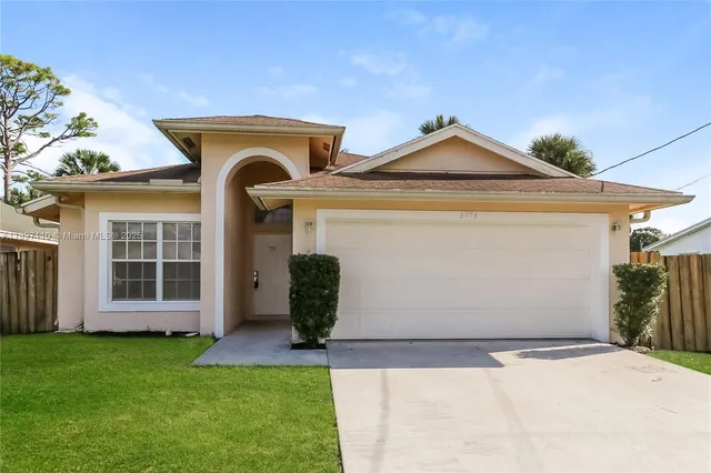 a front view of a house with a garden and plants