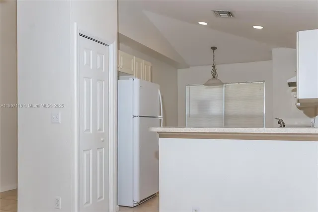 a view of a hallway with a dining table and wooden cabinets