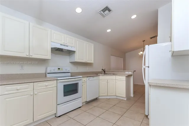 a kitchen with white cabinets and white appliances
