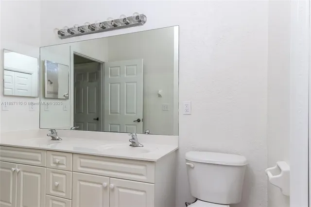 a bathroom with a sink a toilet and a mirror