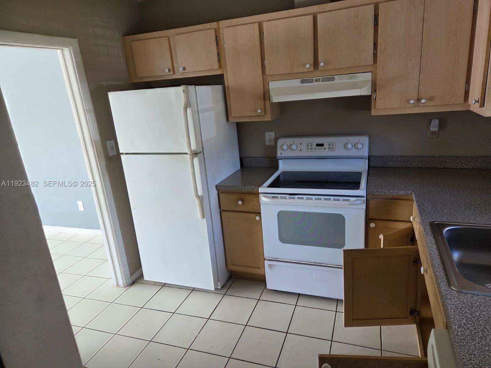 12412 Southwest 112th Terrace Miami, FL 33186 - Photo 4 of 18 a kitchen with a stove top oven and cabinets