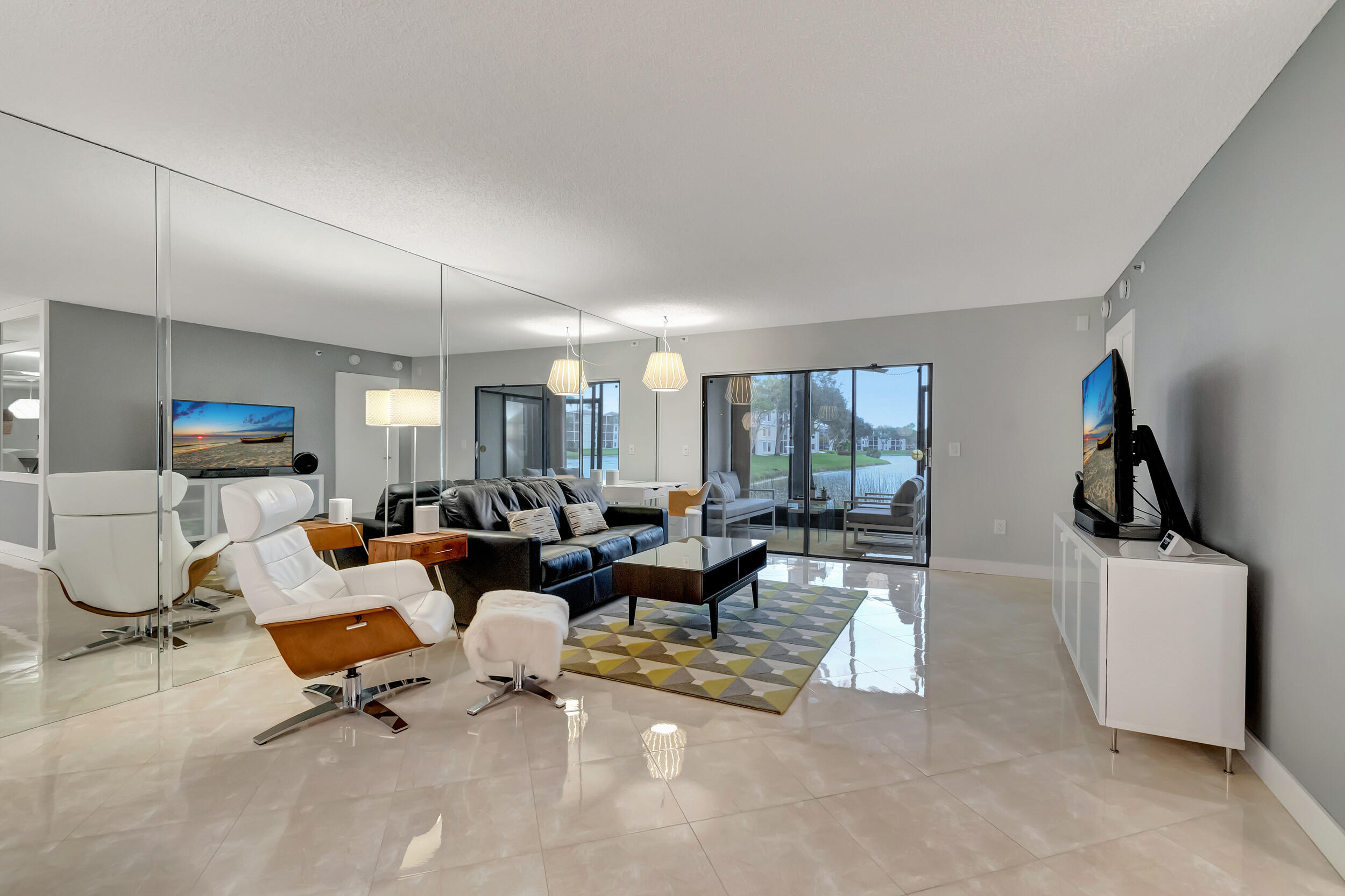6269 Pointe Regal Circle, Unit 102 Delray Beach, FL 33484 - Photo 13 of 51 a living room with furniture and a flat screen tv