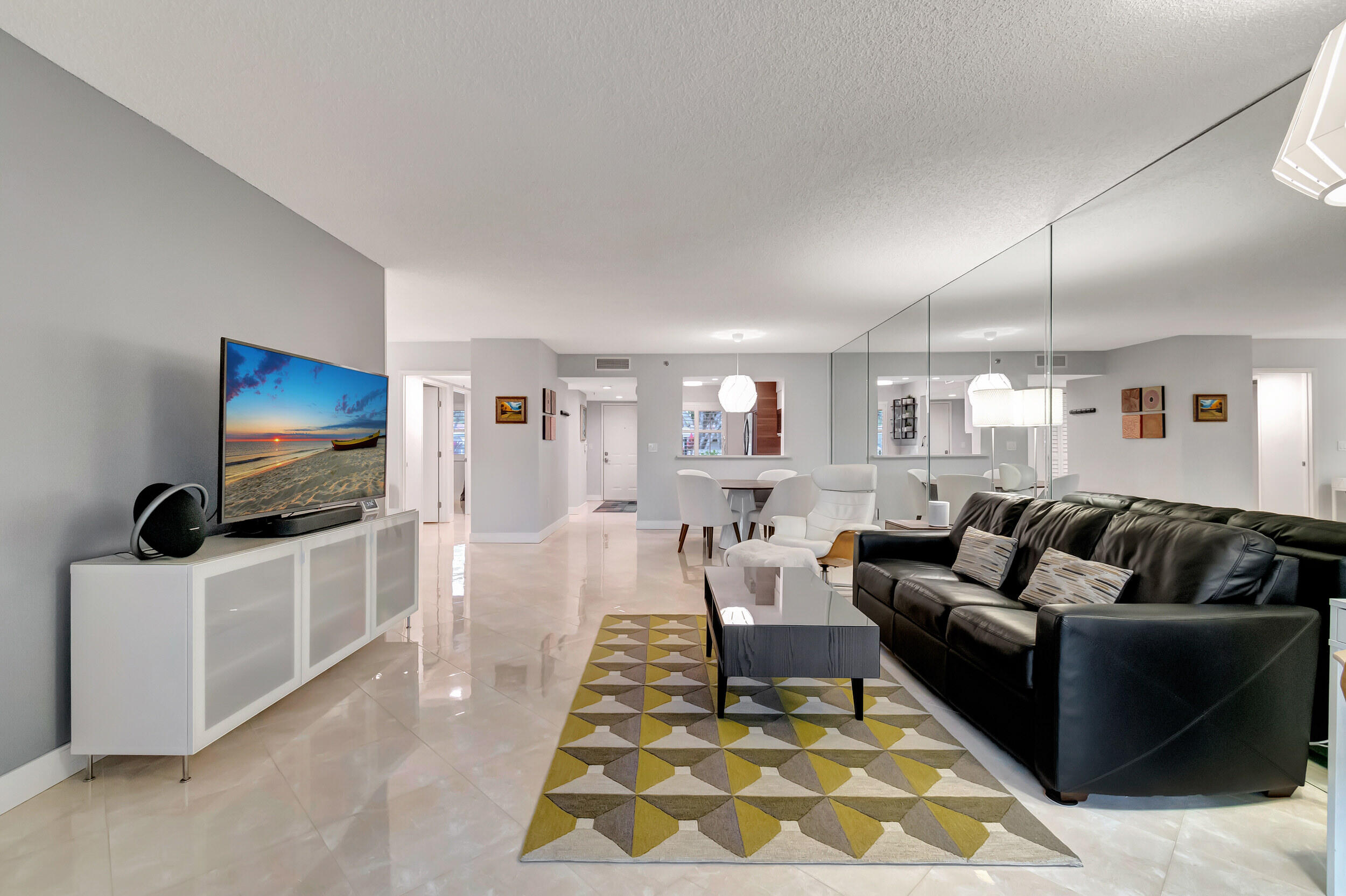 6269 Pointe Regal Circle, Unit 102 Delray Beach, FL 33484 - Photo 17 of 51 a living room with furniture and a flat screen tv