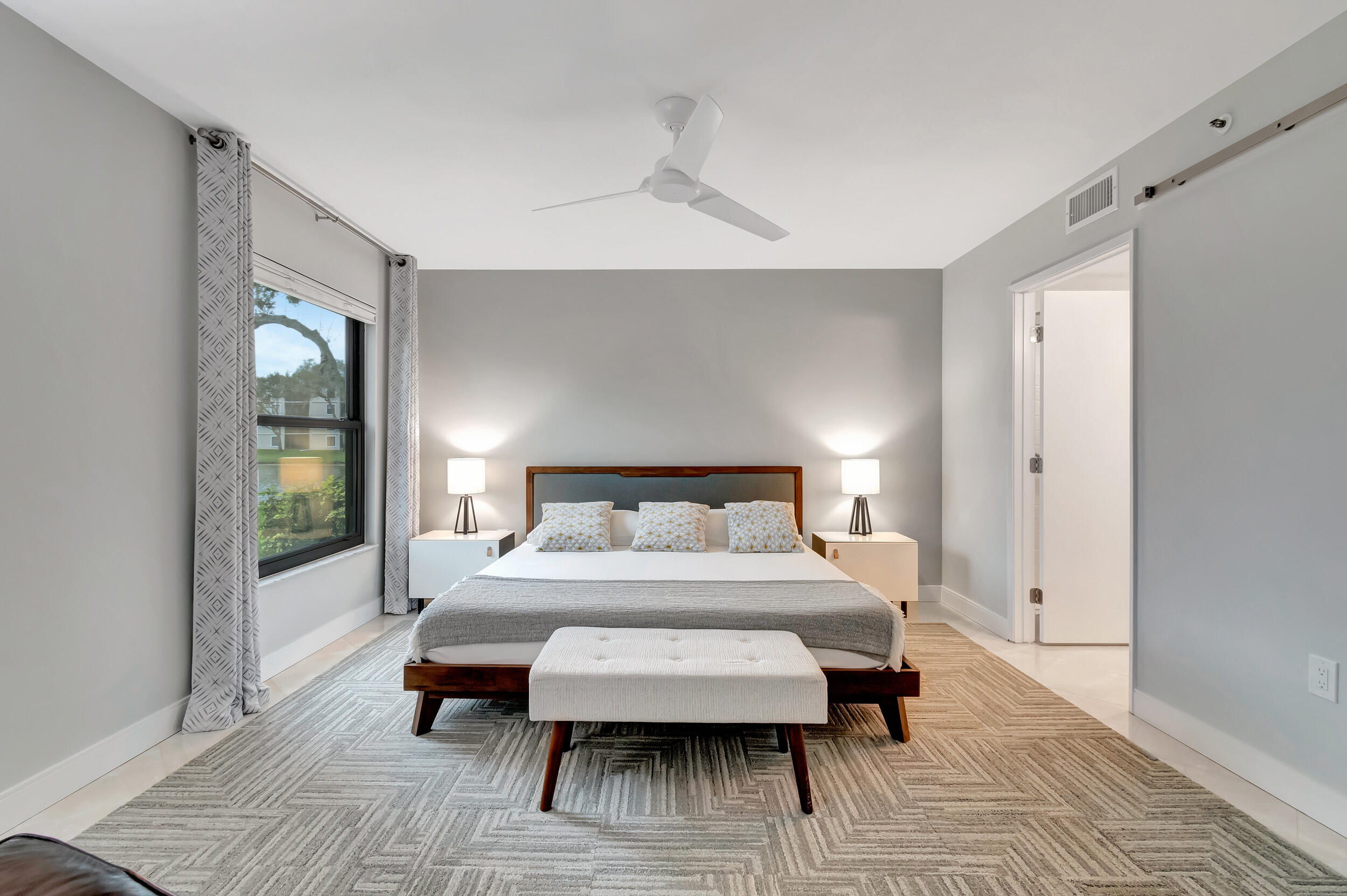 6269 Pointe Regal Circle, Unit 102 Delray Beach, FL 33484 - Photo 22 of 51 a bedroom with a bed and wooden floor