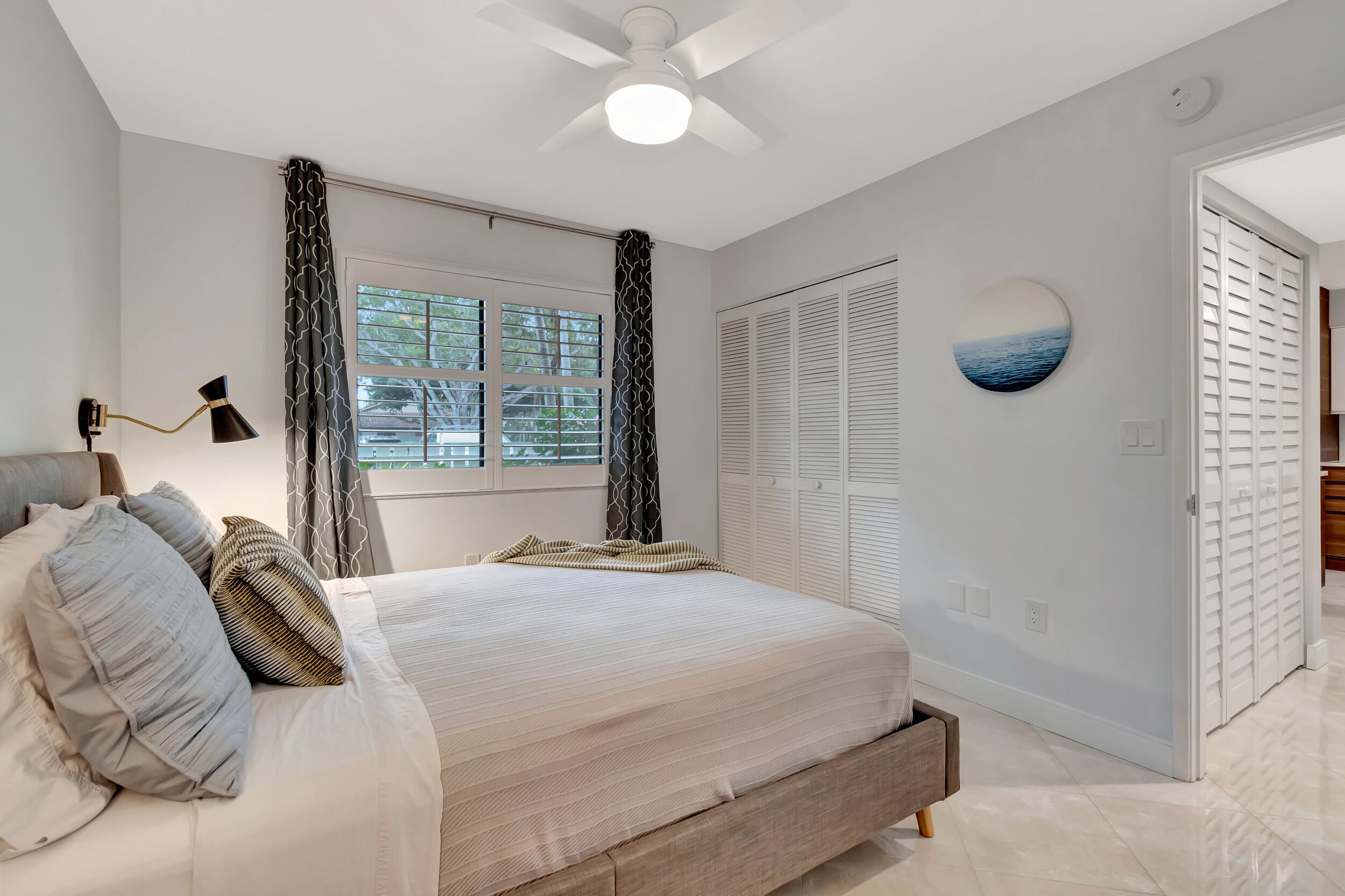 6269 Pointe Regal Circle, Unit 102 Delray Beach, FL 33484 - Photo 27 of 51 a bedroom with a large bed and a large window