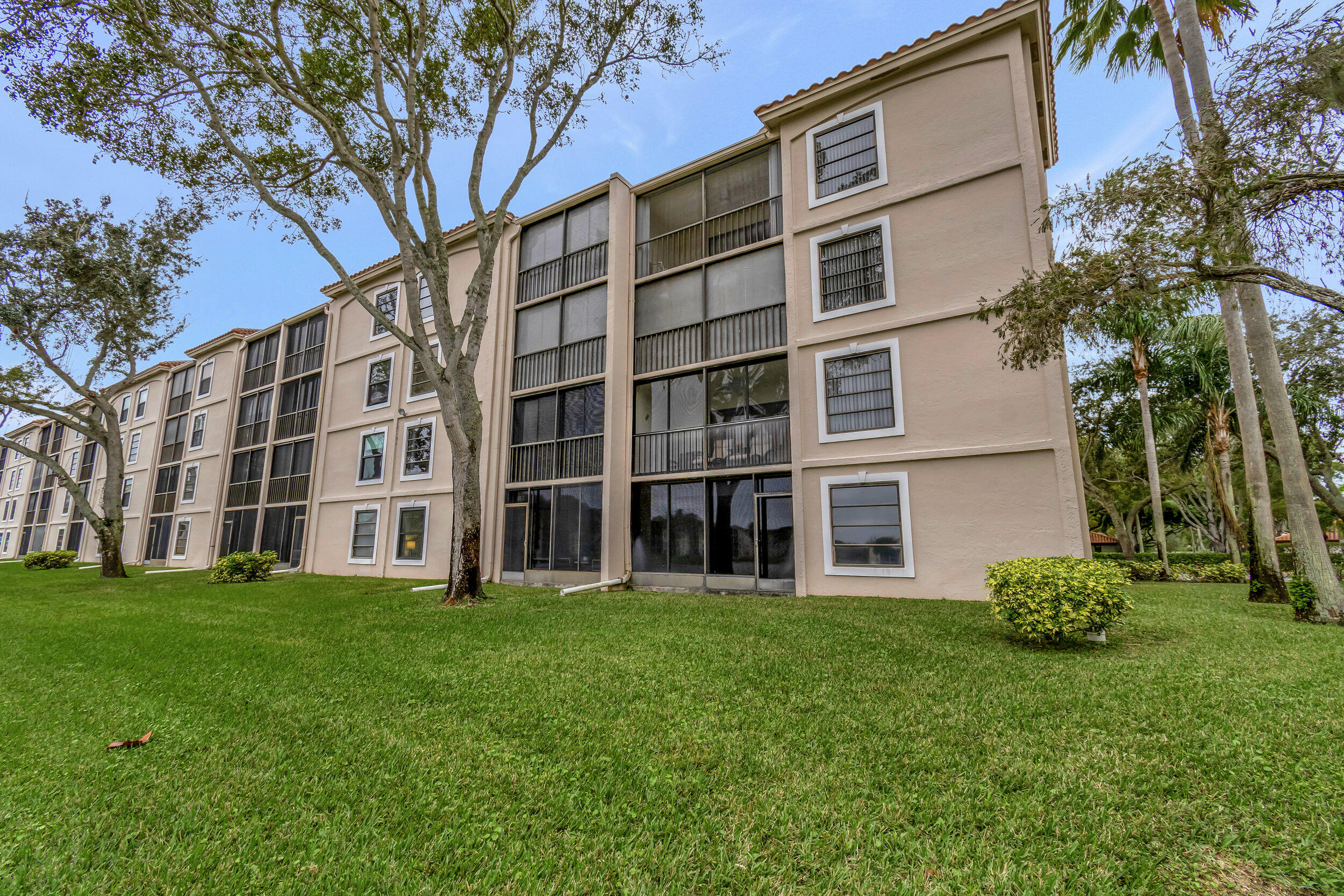6269 Pointe Regal Circle, Unit 102 Delray Beach, FL 33484 - Photo 35 of 51 a large building with a yard