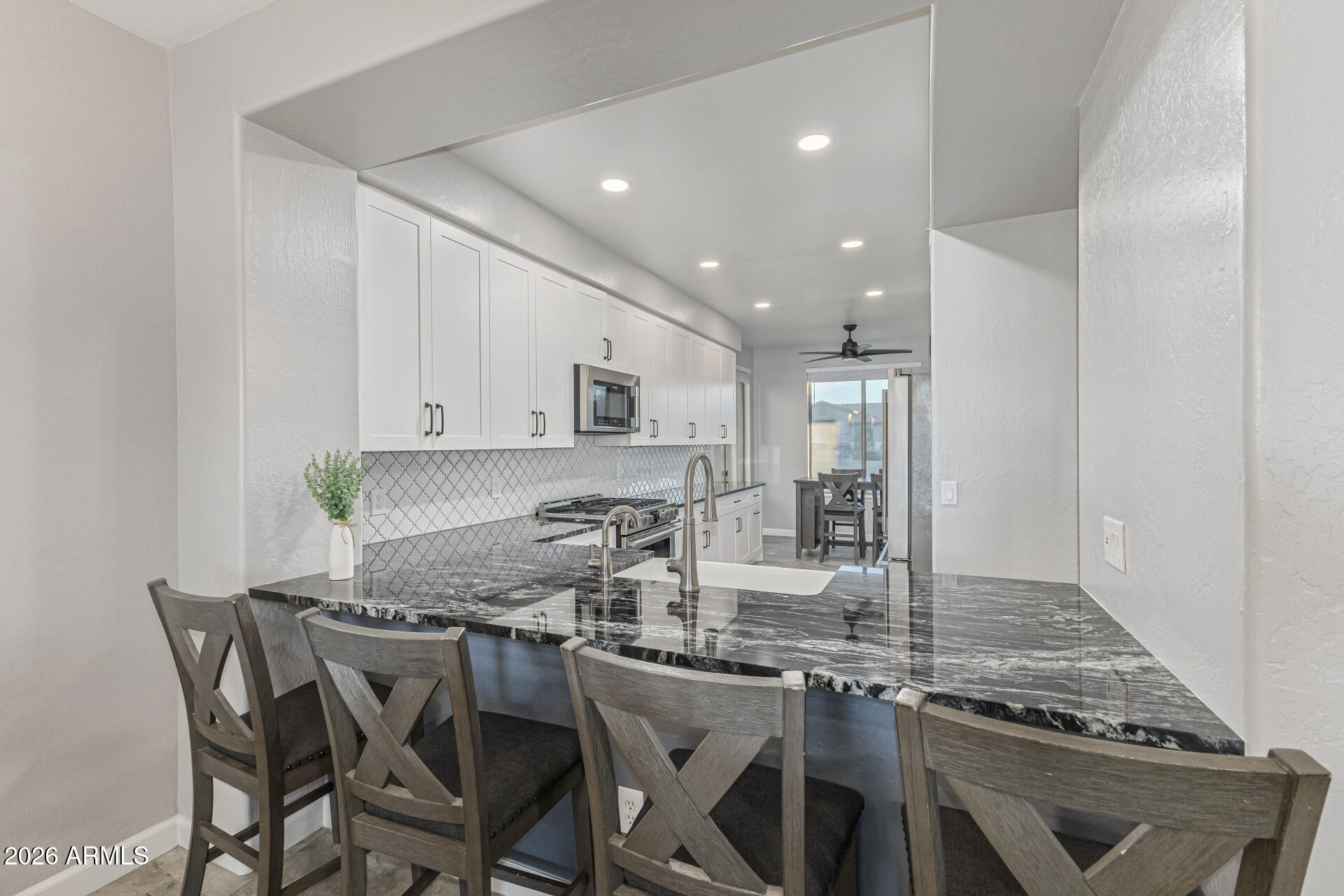 2500 East Milky Way Gilbert, AZ 85295 - Photo 8 of 33 a kitchen with stainless steel appliances granite countertop a stove top oven a sink a dining table and chairs