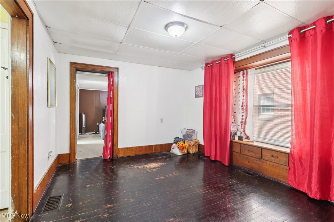 764 Chalker Street Akron, OH 44310 - Photo 9 of 34 Empty room with dark wood-style floors and a paneled ceiling