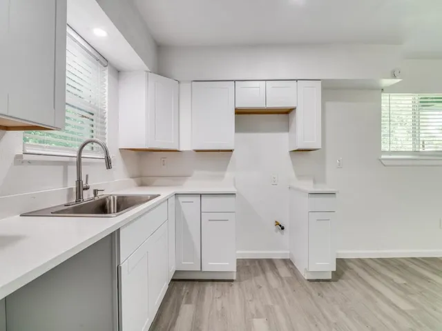 a kitchen with a sink cabinets stainless steel appliances and a window