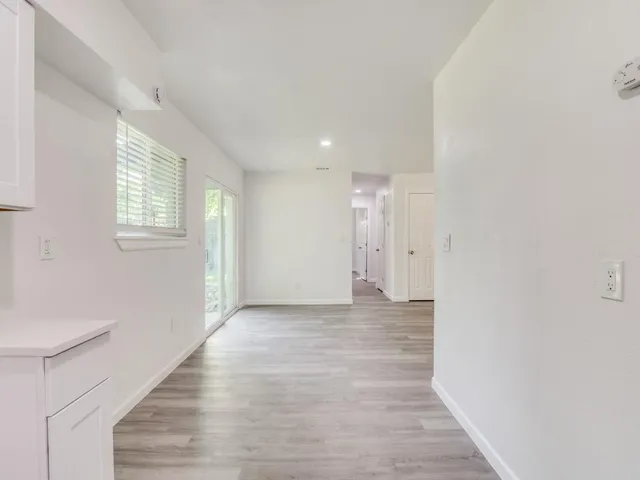 a view of an empty room with wooden floor