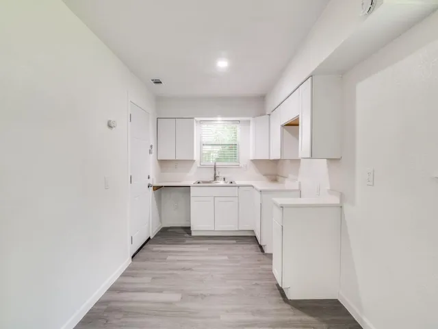 a kitchen with granite countertop white cabinets and white appliances