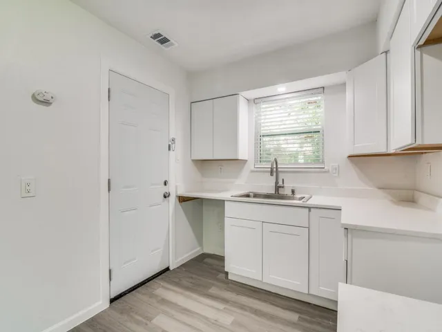 a kitchen with a sink cabinets and window