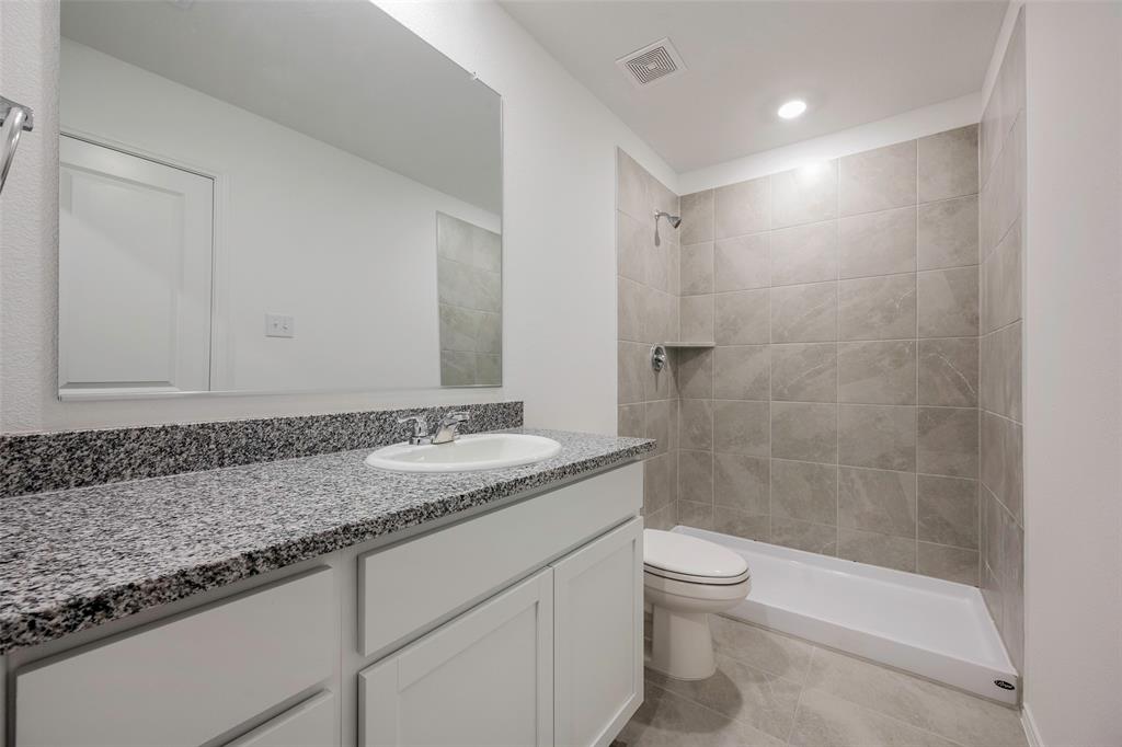 209 Boxberry Way Princeton, TX 75407 - Photo 12 of 34 a bathroom with a granite countertop sink a toilet and shower