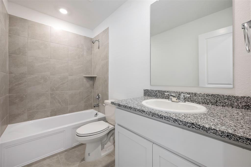 209 Boxberry Way Princeton, TX 75407 - Photo 14 of 34 a bathroom with a granite countertop toilet a sink and a bathtub