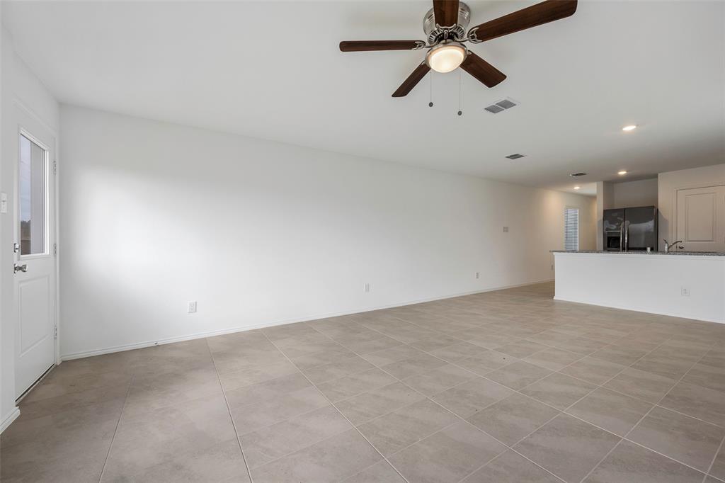 209 Boxberry Way Princeton, TX 75407 - Photo 6 of 34 an empty room with chandelier fan and windows