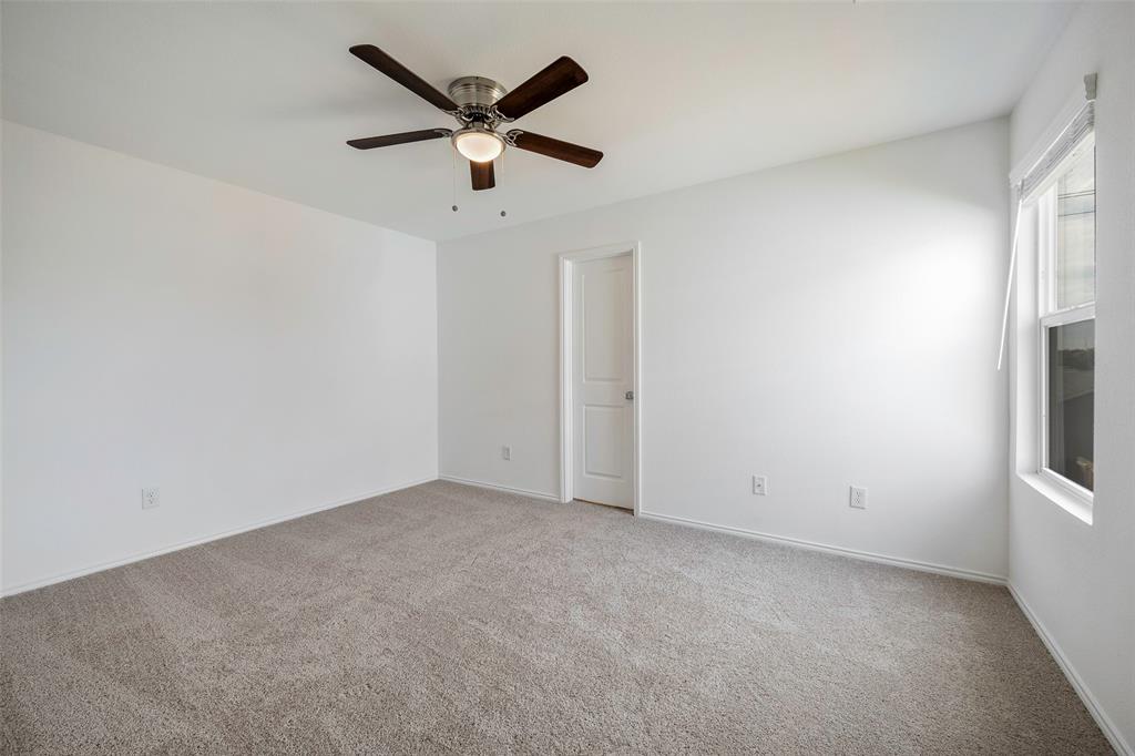 209 Boxberry Way Princeton, TX 75407 - Photo 10 of 34 an empty room with a window and a fan