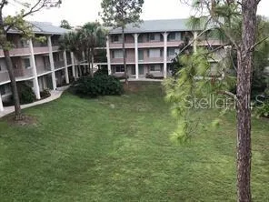 a view of a large building with a big yard and large trees