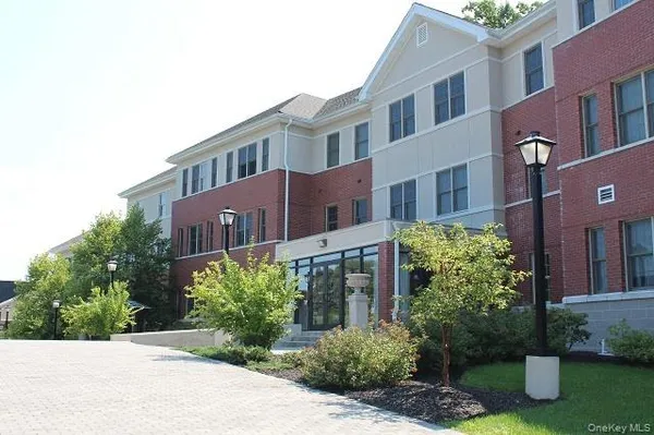 a front view of a multi story residential apartment building with a yard