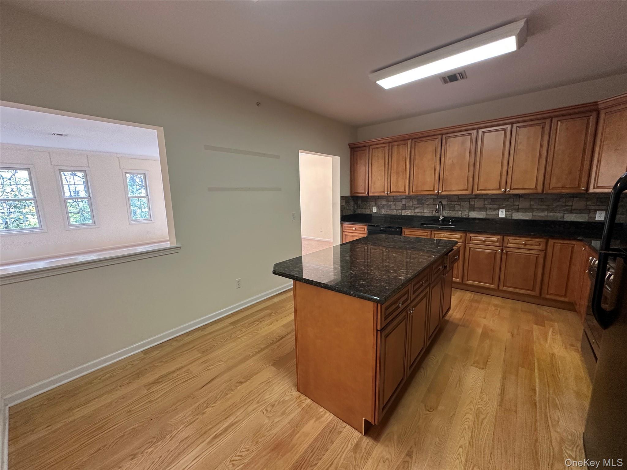 75 Quaker Avenue, Unit 315 Cornwall, NY 12518 - Photo 16 of 48 a kitchen with wooden cabinets a sink and a stove