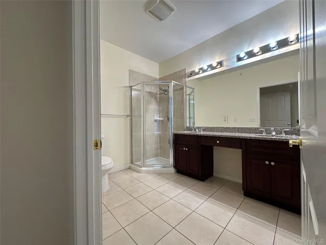 a spacious bathroom with a granite countertop sink mirror and a bathtub