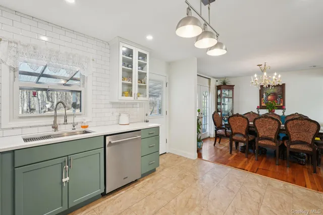a kitchen with kitchen island a dining table chairs and refrigerator