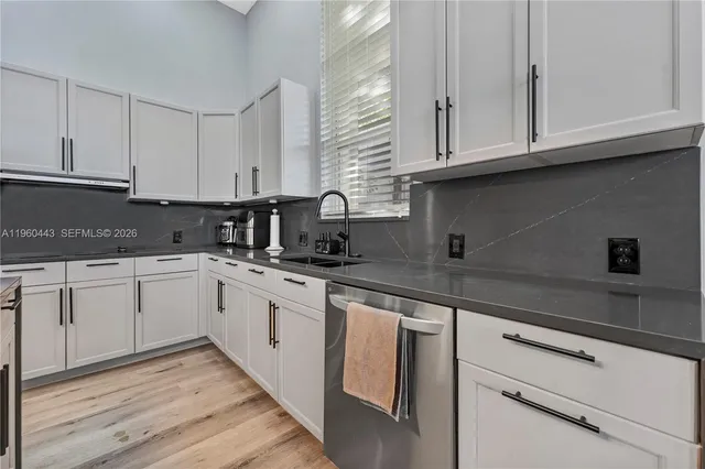 a kitchen with granite countertop cabinets stainless steel appliances and sink