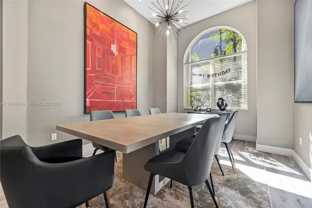 a view of a dining room with furniture a chandelier and wooden floor