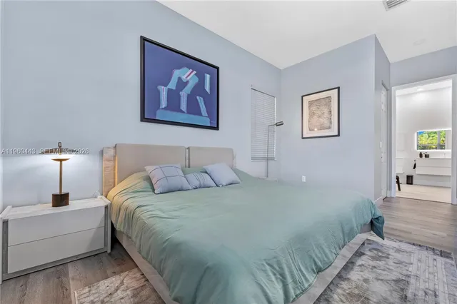 a bedroom with a bed and a lamp on dresser