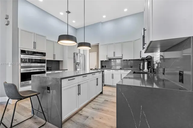 a open kitchen with stainless steel appliances granite countertop a sink a stove top oven a counter space and cabinets