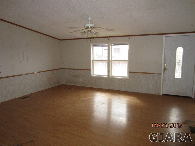 1752 L L 1/2 Road Fruita, CO 81521 - Photo 5 of 6 an empty room with wooden floor and windows