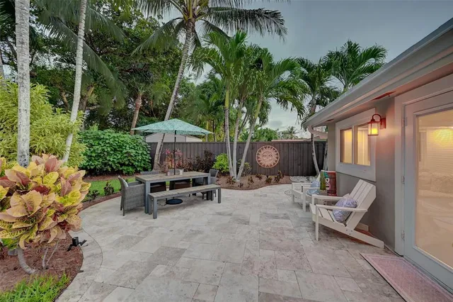 a view of patio with a table and chairs under an umbrella