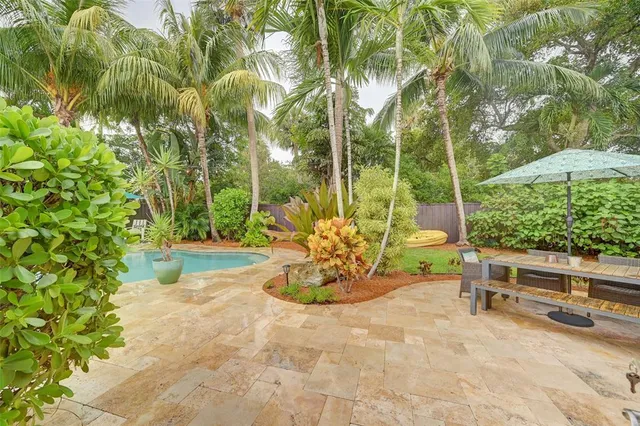 a view of a backyard with table and chairs potted plants