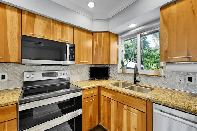a kitchen that has a sink and a stove top oven