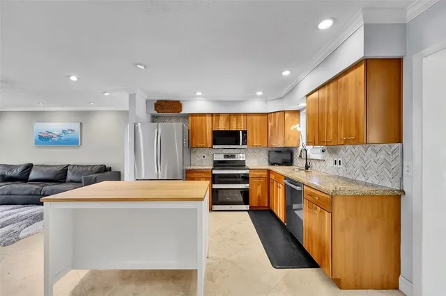 a large kitchen with stainless steel appliances kitchen island granite countertop a sink and cabinets