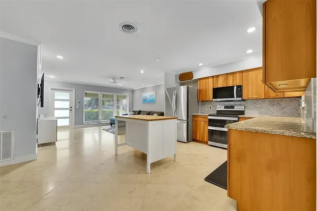 a kitchen with a sink a counter top space appliances and cabinets