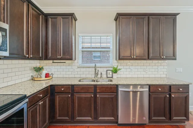 a kitchen with stainless steel appliances granite countertop wooden cabinets a sink and dishwasher