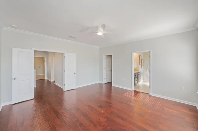a view of an empty room with wooden floor and closet