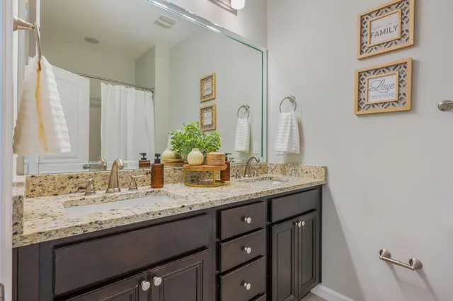a bathroom with a granite countertop sink and a mirror