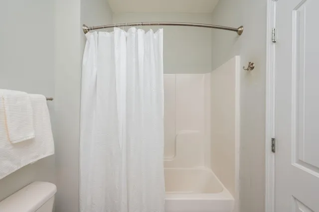 a bathroom with a shower curtain and a toilet next
