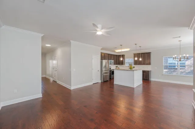 a view of kitchen with kitchen island and stainless steel appliances with wooden floor
