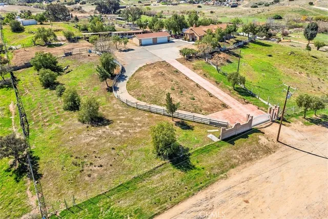 an aerial view of a house with a yard and lake view