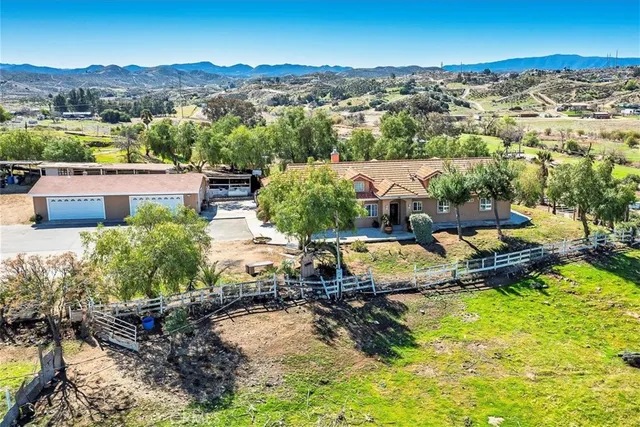 an aerial view of a house with a garden and lake view